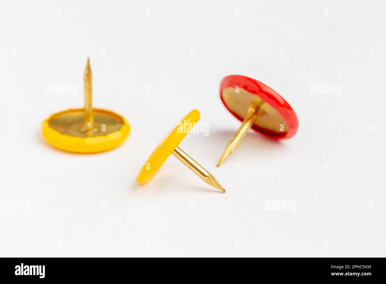 Three drawing pins on a white background. Stock Photo