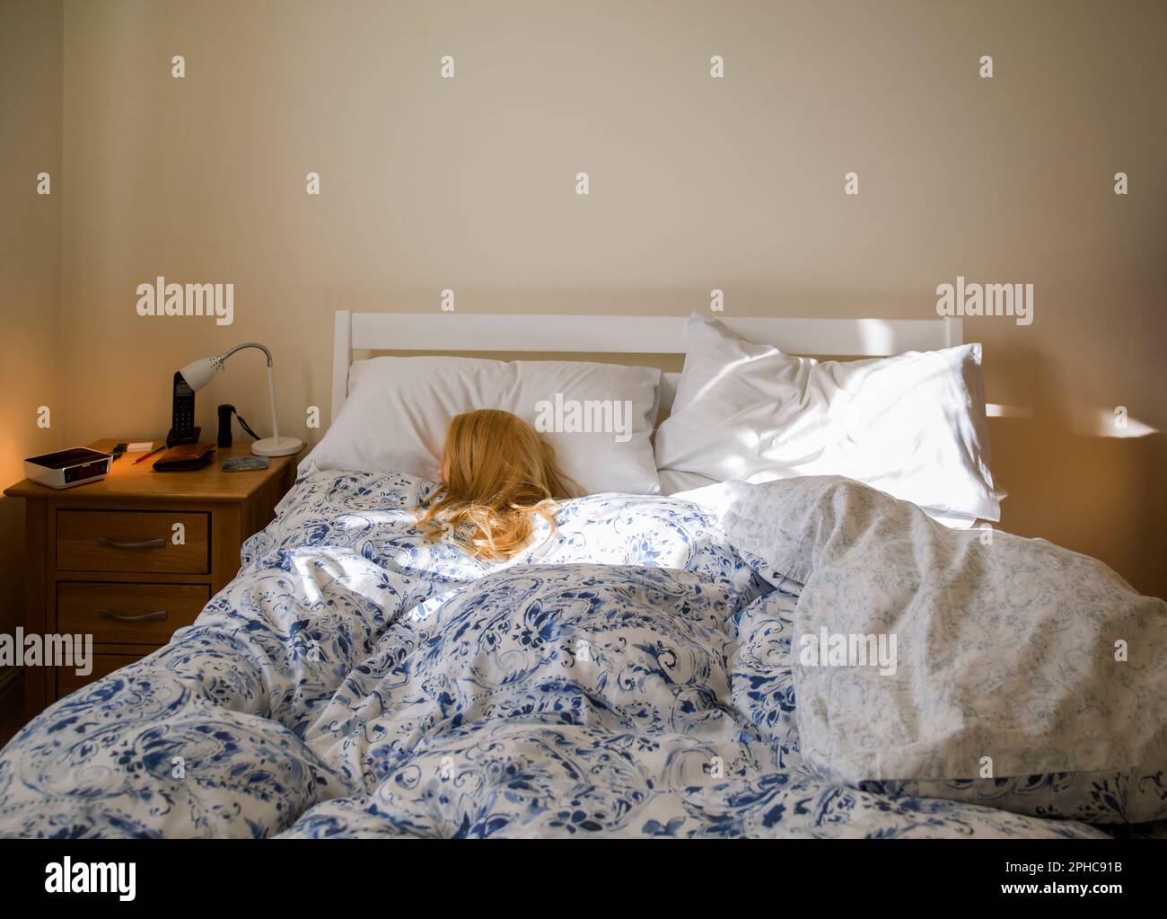 Blond Woman (mannequin) Sleeping In Bed Lit by Morning Sunshine Stock Photo