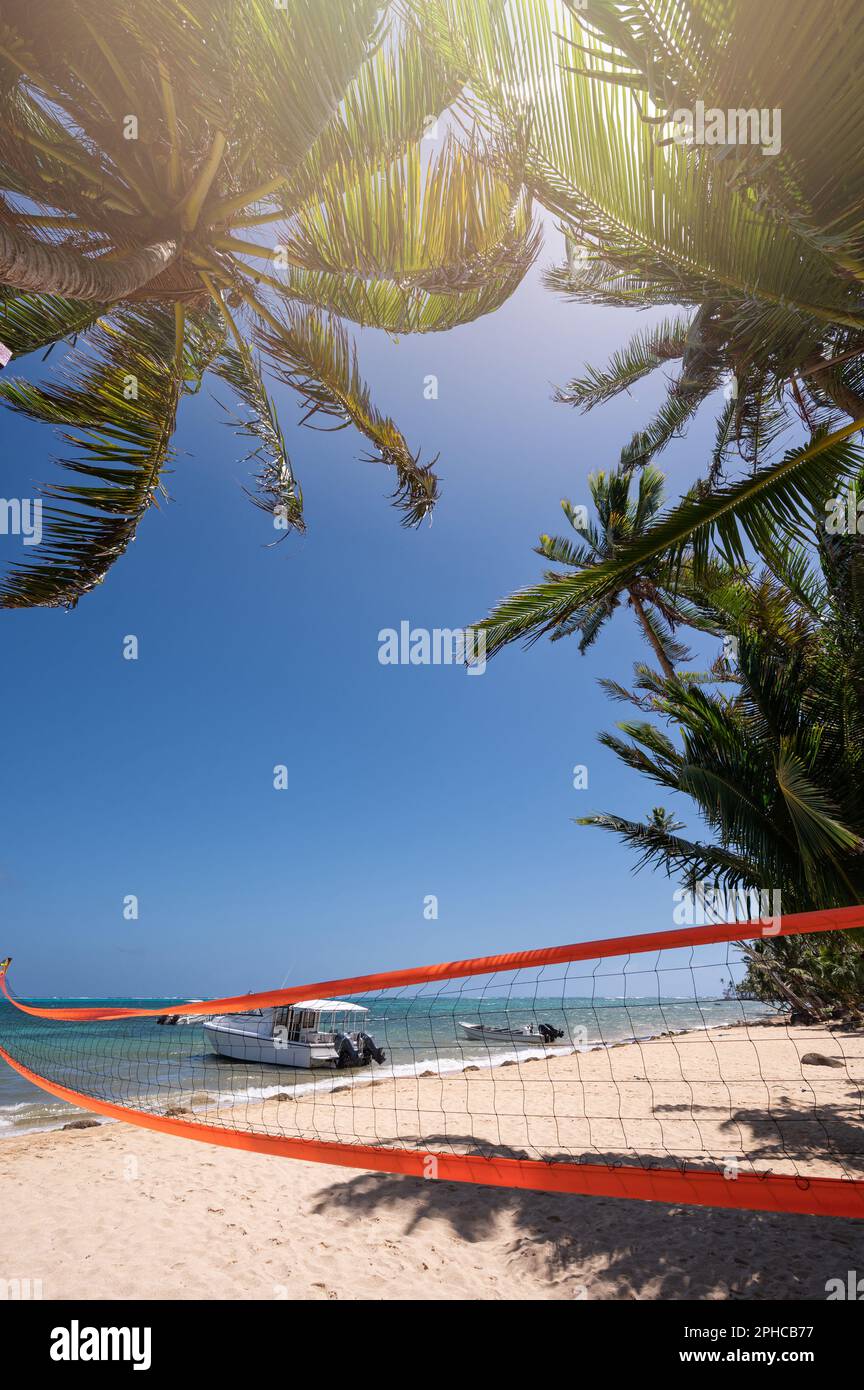 Orange volleyball net on tropical blue background. Activity volley game