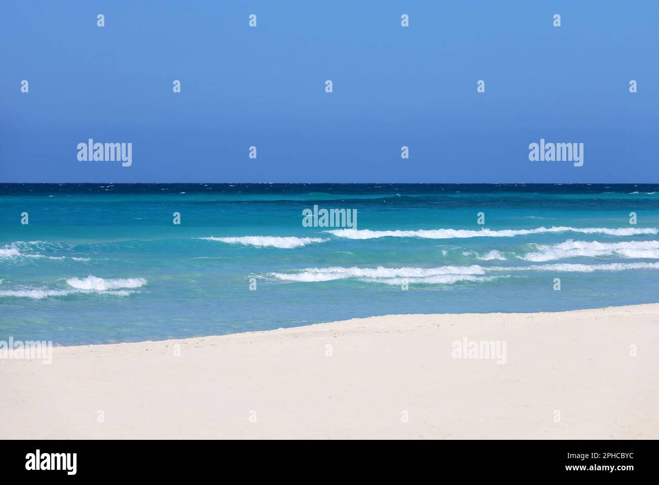 Empty sea beach with white sand, view to azure waves and blue sky. Caribbean coast, Background for holidays on a paradise nature Stock Photo