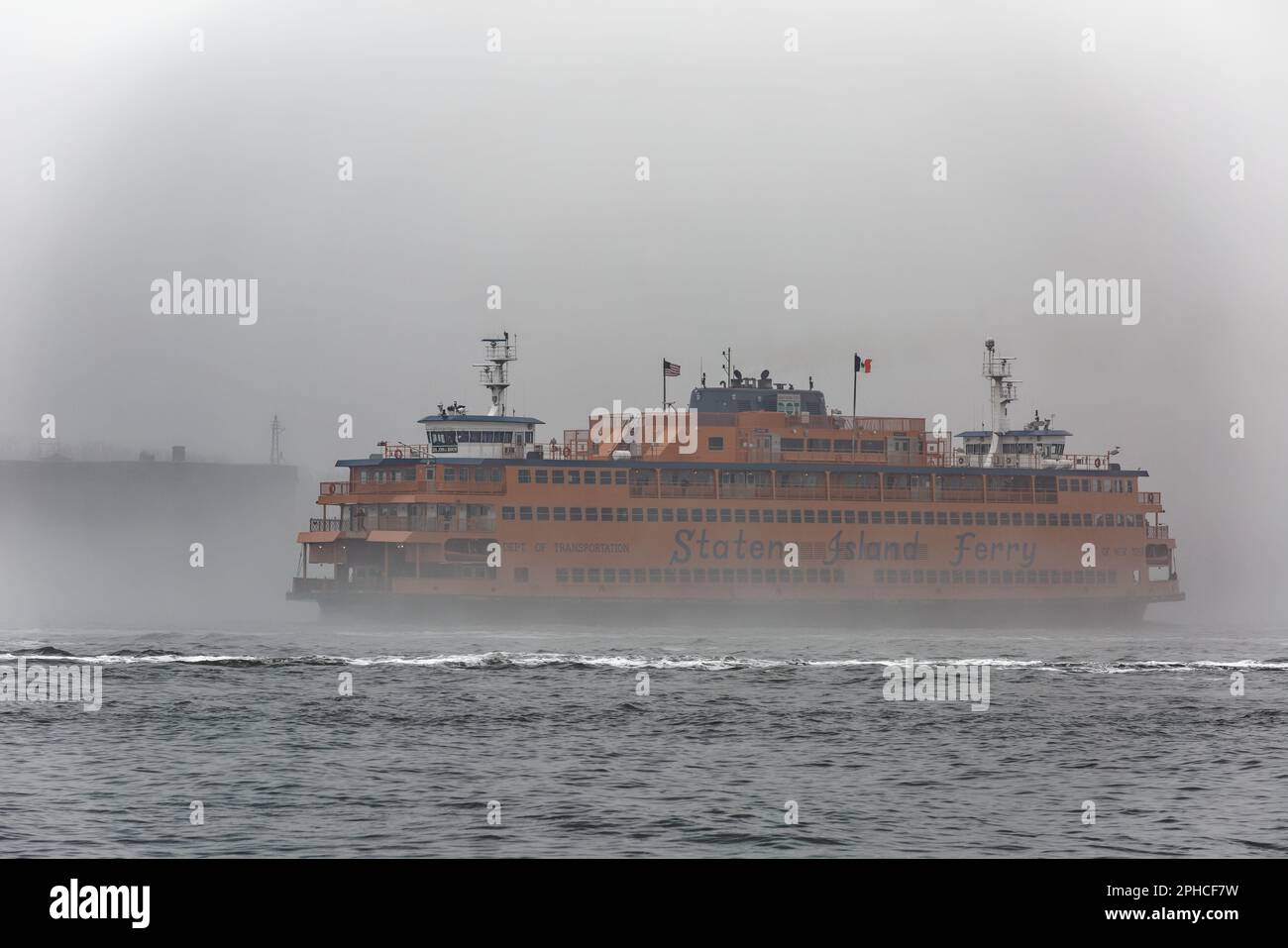 The Staten Island Ferry is the only spot of color on a foggy February