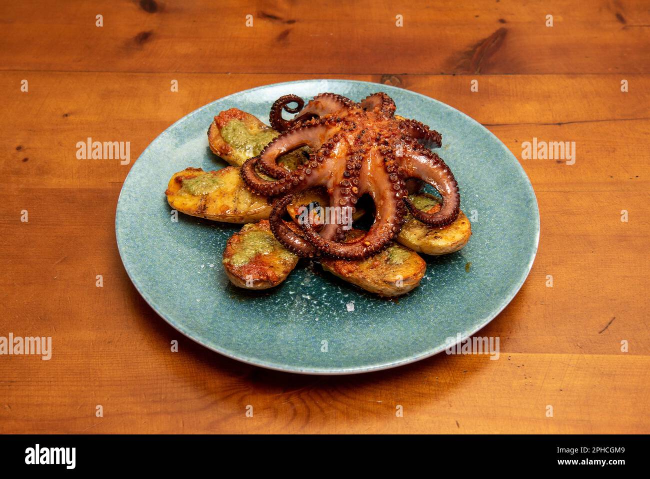 How to make grilled octopus. Octopus juicy on the inside and crunchy on the outside, with potatoes and a delicious ajoaceite Stock Photo