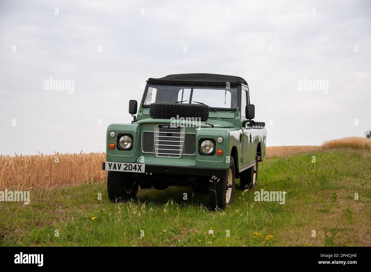 Land Rover Series Three pickup truck with soft top cab parked on grass