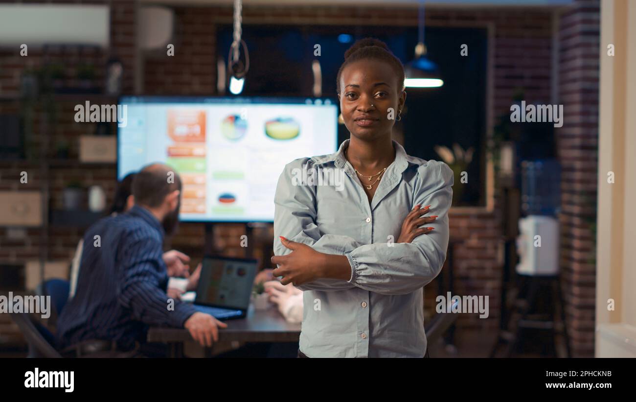 Smiling african american businesswoman crossing arms portrait, front ...