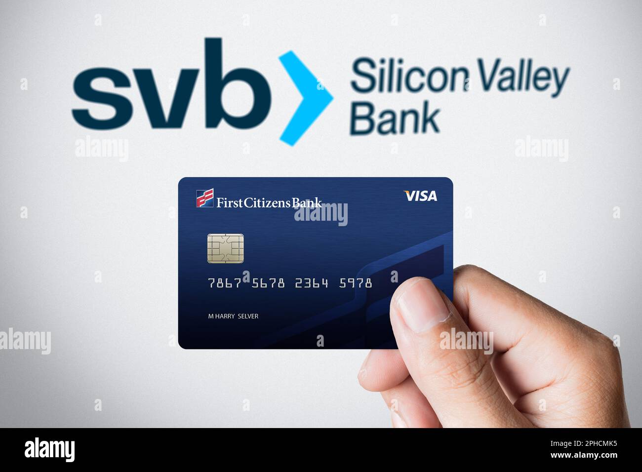 Close up hand holds First Citizens Visa Debit Card front of Silicon