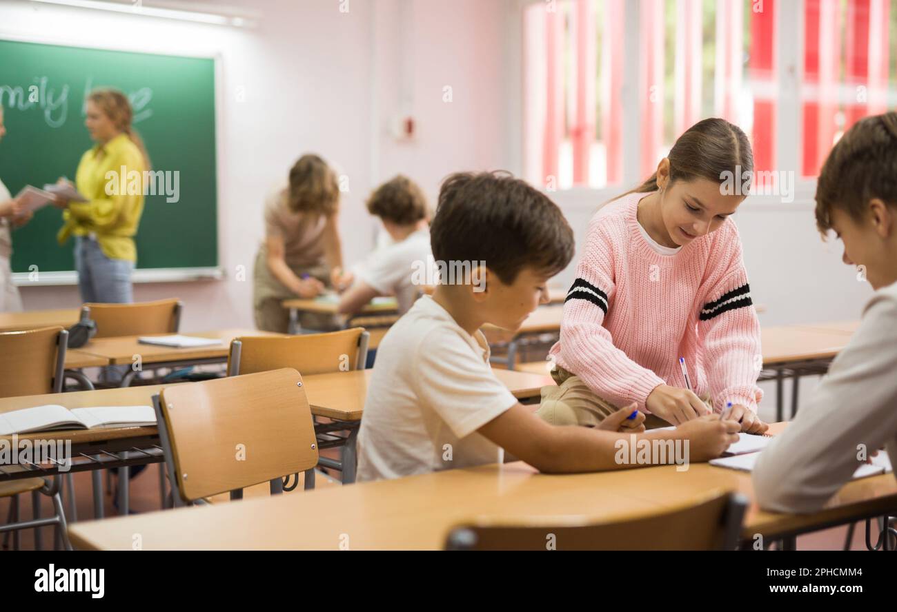 Schoolchilds working in groups at lesson Stock Photo