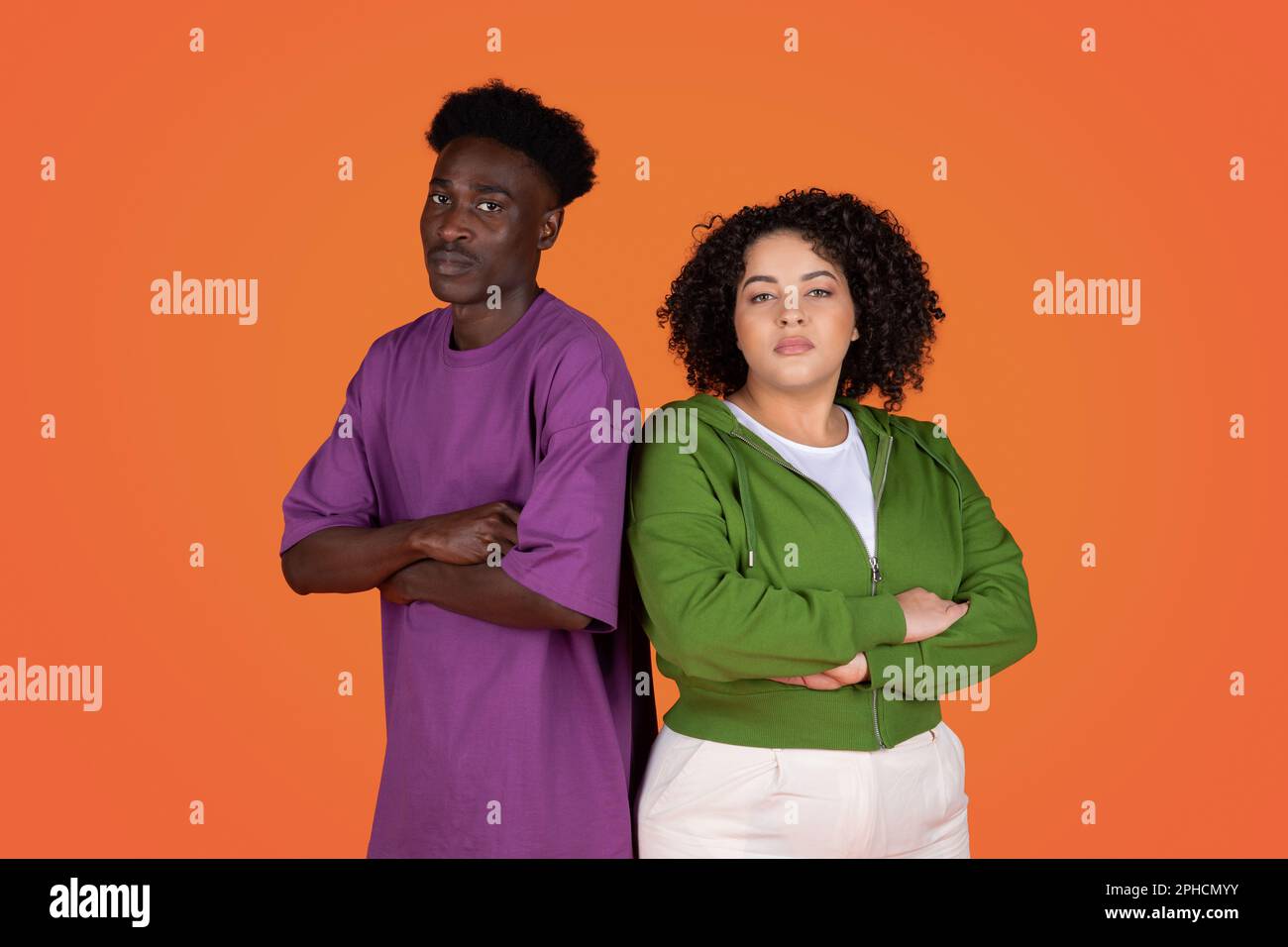 Upset couple standing back to back on red background Stock Photo