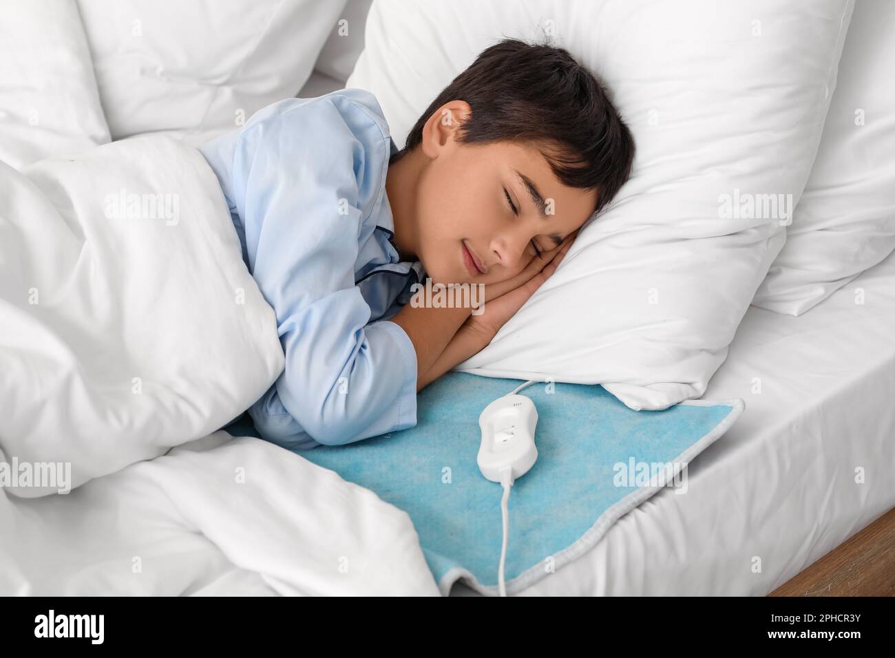 Little boy sleeping on electric heating pad in bedroom Stock Photo Alamy