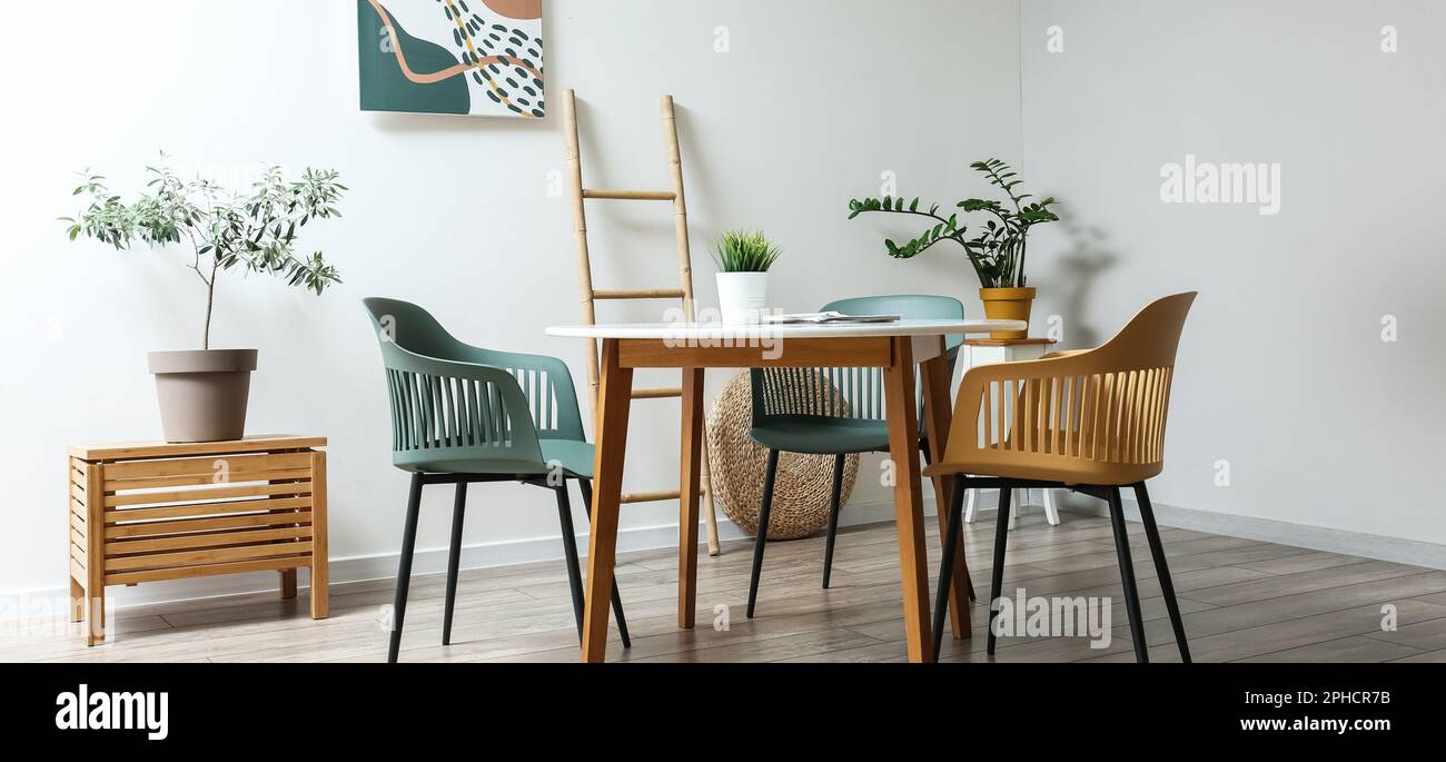 Stylish interior of dining room with modern furniture and houseplants ...