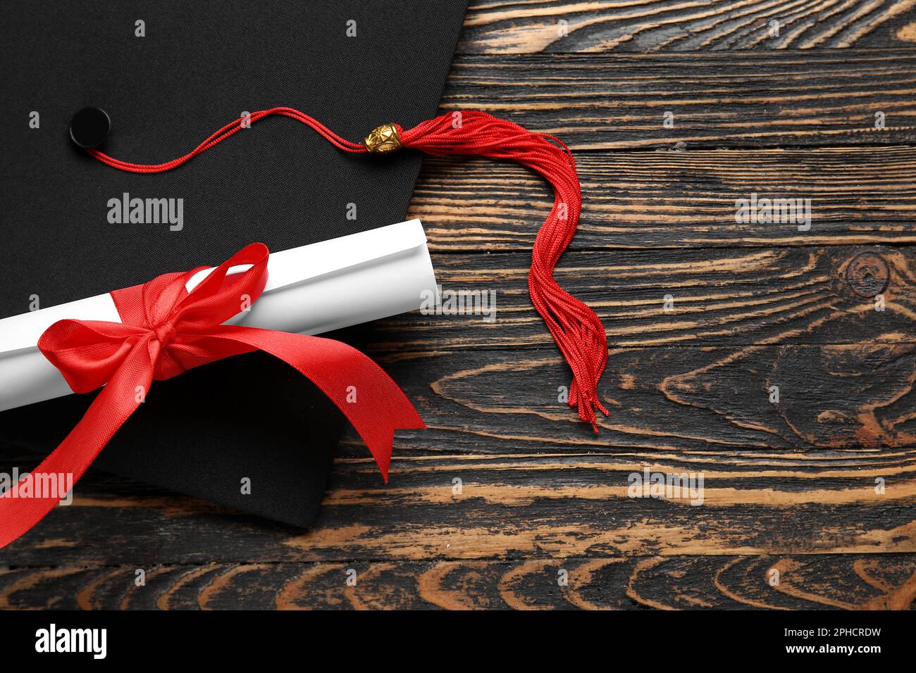 Diploma with red ribbon and graduation hat on wooden table Stock Photo ...