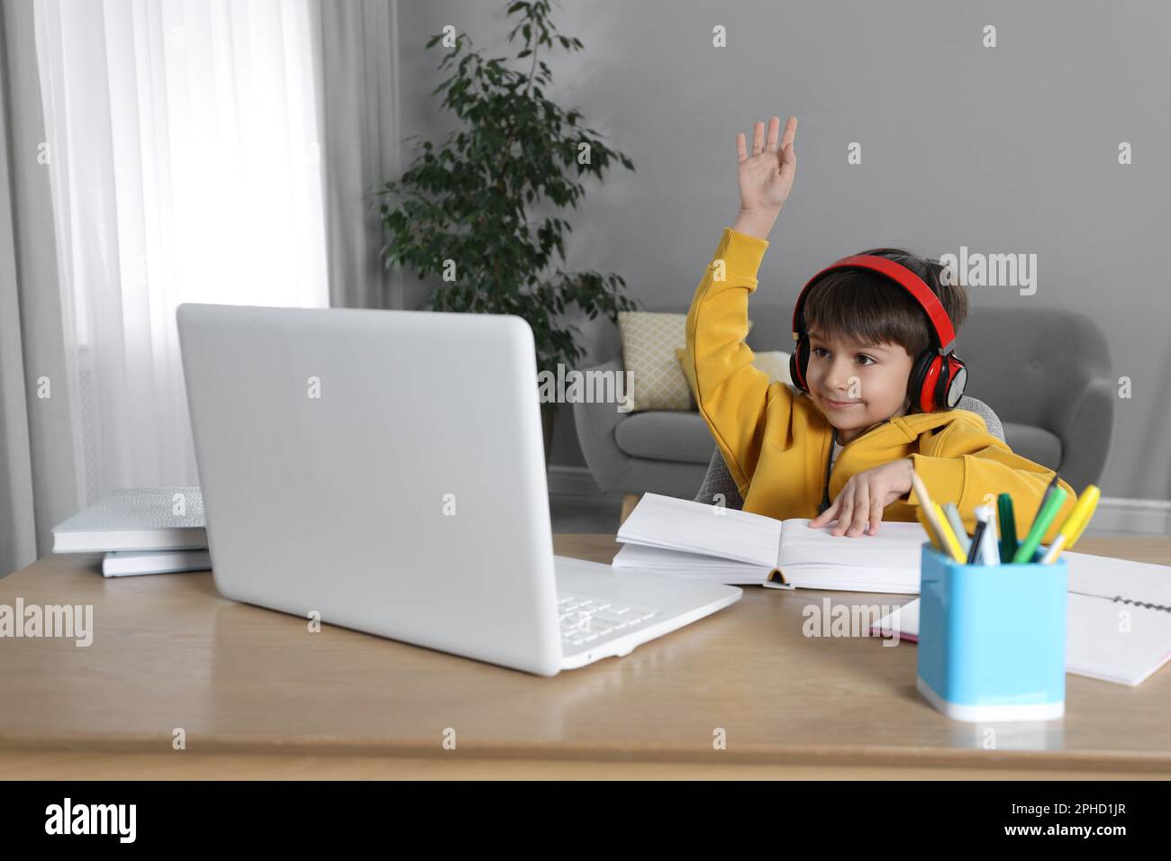 Cute little boy with modern laptop studying online at home. E-learning ...