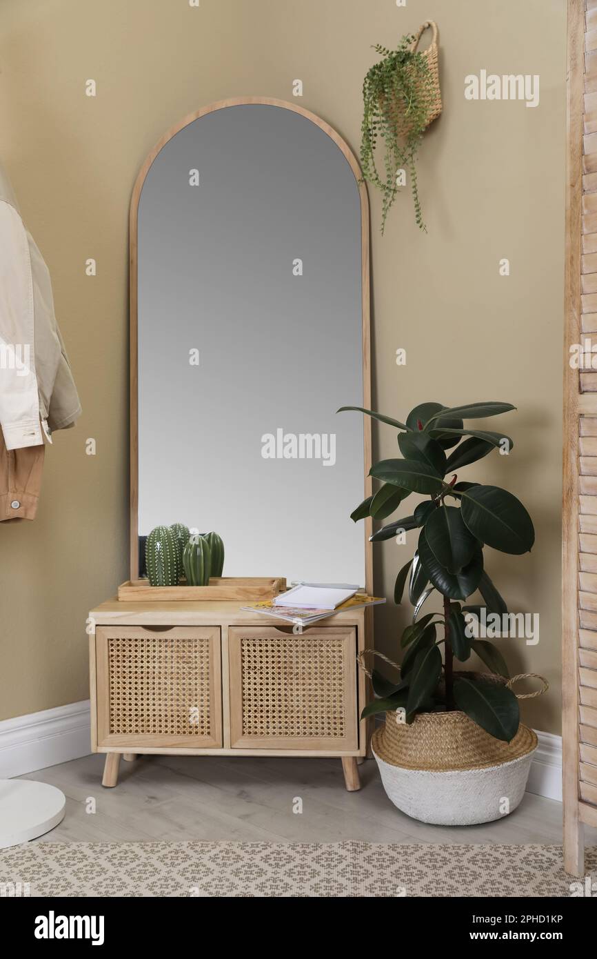 Stylish hallway room interior with wooden commode and large mirror ...