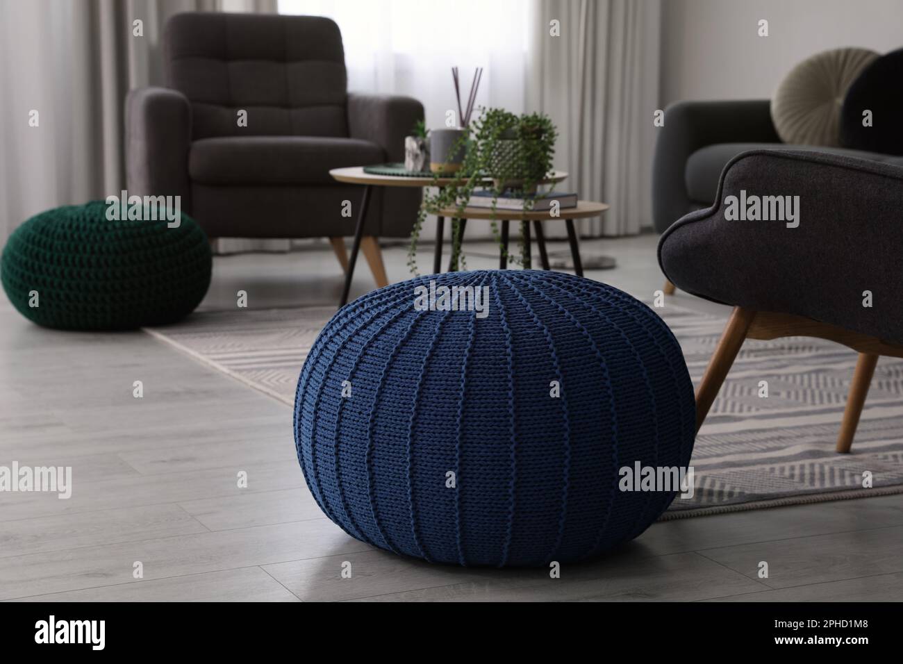 Stylish comfortable poufs and armchairs in room. Home design Stock Photo Alamy