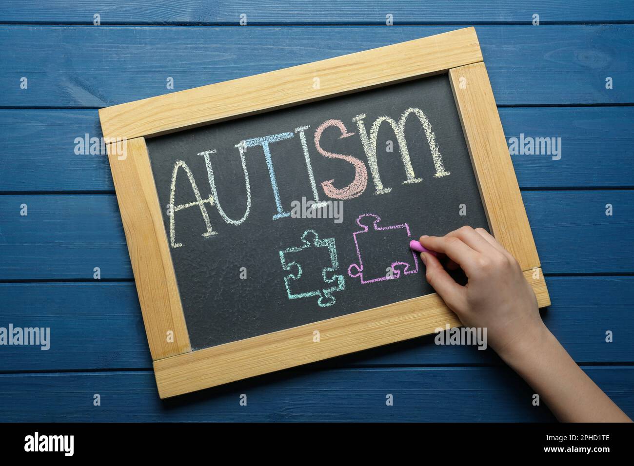 Woman Drawing Jigsaw Puzzle Pieces Below Word Autism On Chalkboard At