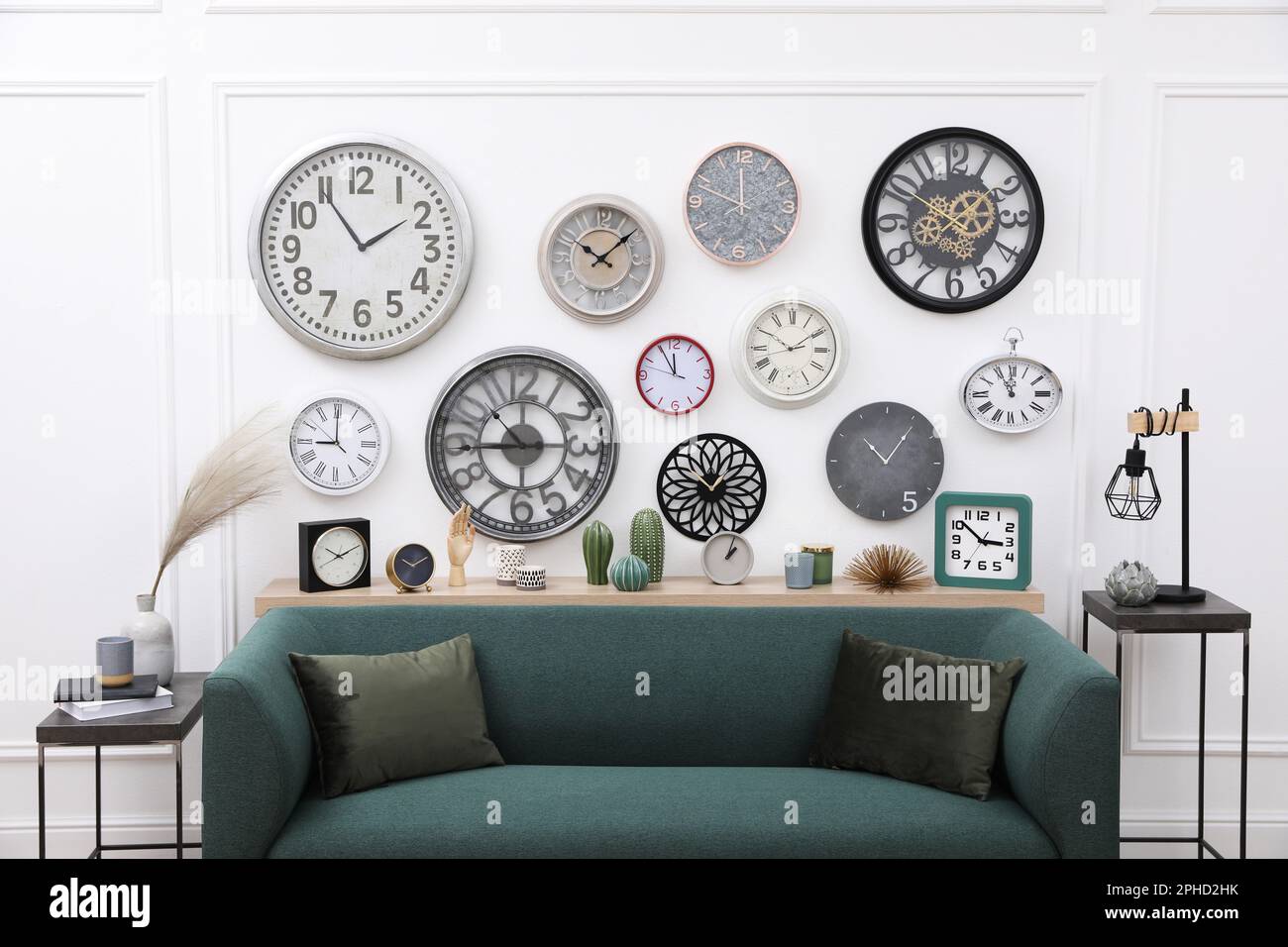 Collection of different clocks and comfortable sofa in stylish room ...