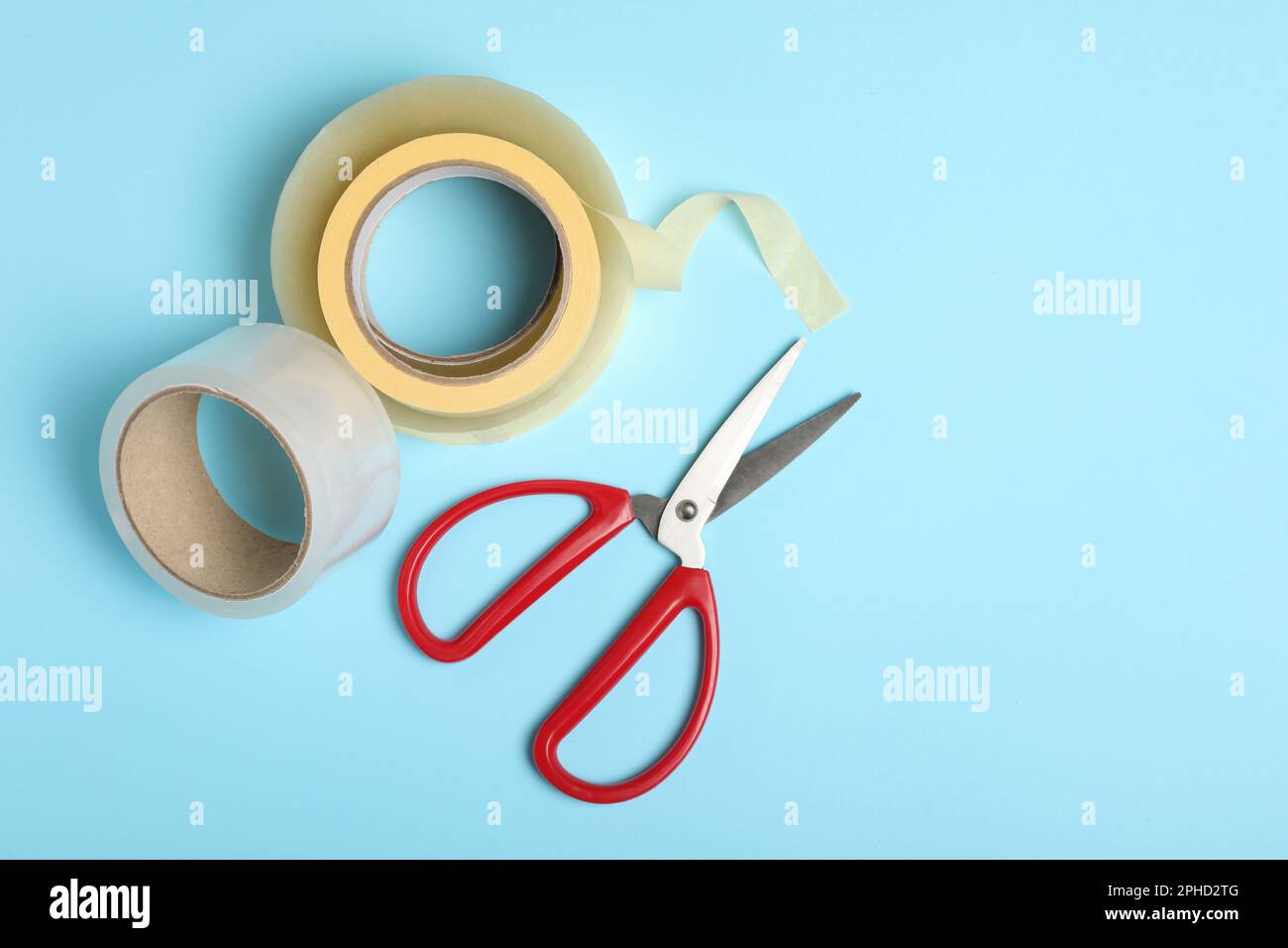 https://c8.alamy.com/comp/2PHD2TG/rolls-of-adhesive-tape-and-scissors-on-light-blue-background-flat-lay-space-for-text-2PHD2TG.jpg