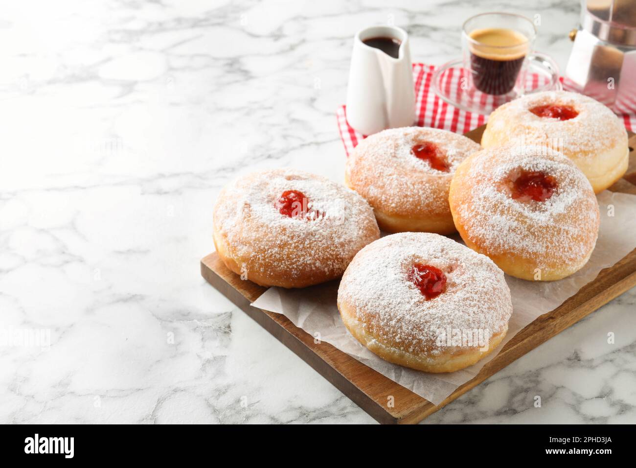 Delicious jam donuts served with coffee on white marble table. Space for text Stock Photo