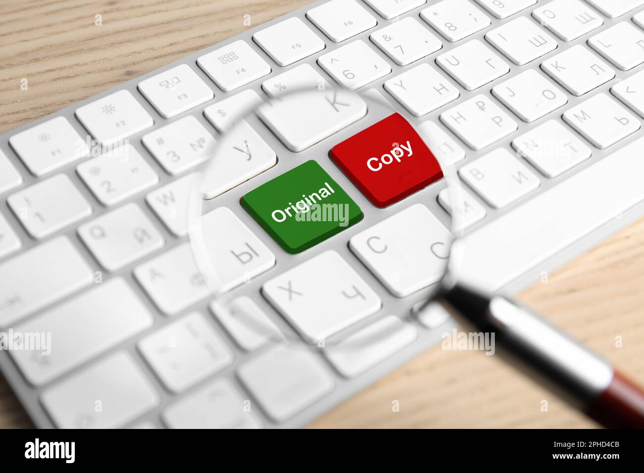 Looking through magnifying glass on color keyboard buttons with words Copy and Original. Plagiarism concept Stock Photo
