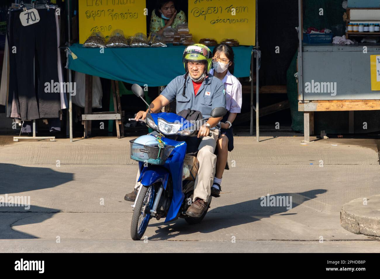 SAMUT PRAKAN, THAILAND, FEB 02 2023, A man ride on a motorbike with a girl in a school uniform. Stock Photo