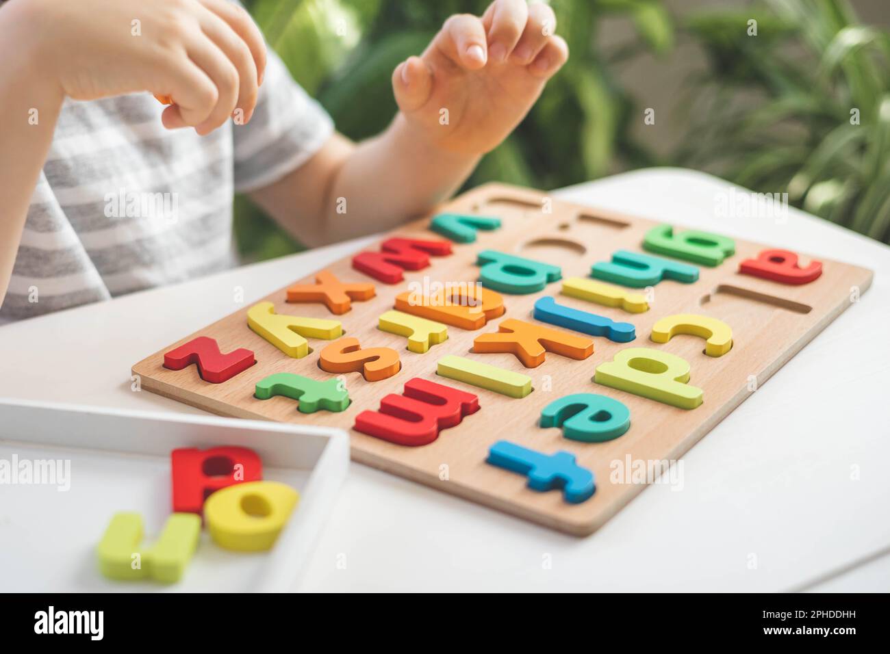 Intellectual Letters Male kid playing with wooden eco friendly alphabet letters board on ...