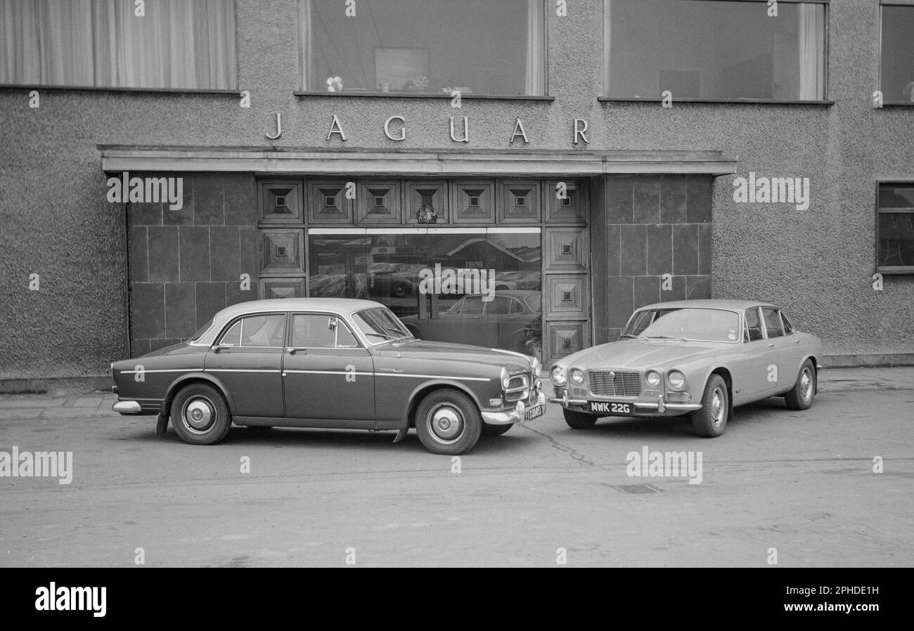 A 1968 photograph showing a Jaguar XJS 4.2, MWK 22G, used as a press car by Jaguar. Also a Volvo 122 Amazon, YJU 451. In front of the Jaguar Offices. Stock Photo