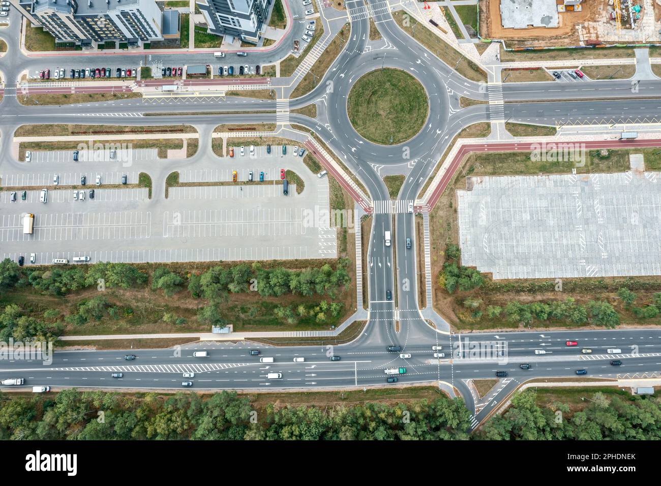 road junction with roundabout and parking lot with parked cars. top down aerial view Stock Photo