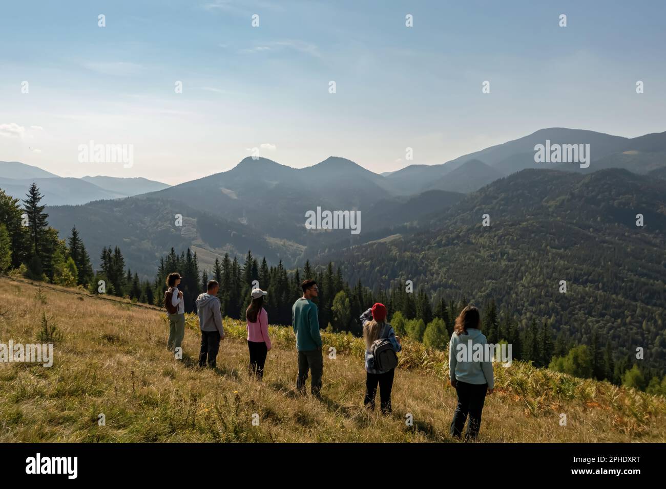 Group of tourists on hill in mountains, back view Stock Photo - Alamy