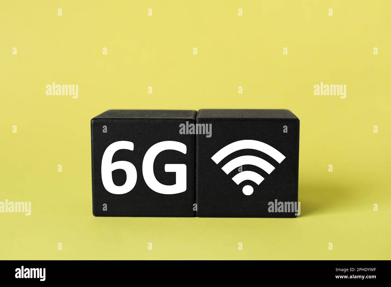 Cubes with 6G and WiFi symbols on yellow background Stock Photo