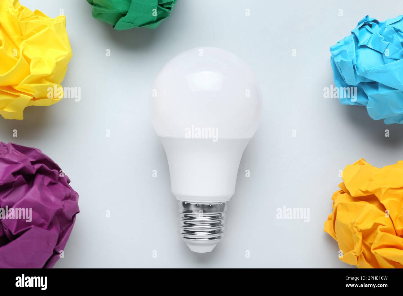 Creative flat lay composition with lightbulb and paper balls on white background. Idea concept Stock Photo