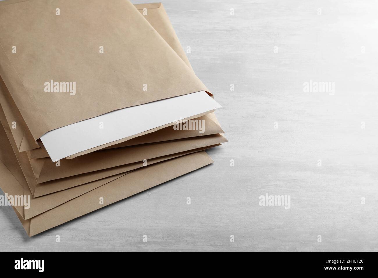 Stack of big kraft paper envelopes on light table, closeup Stock Photo Alamy