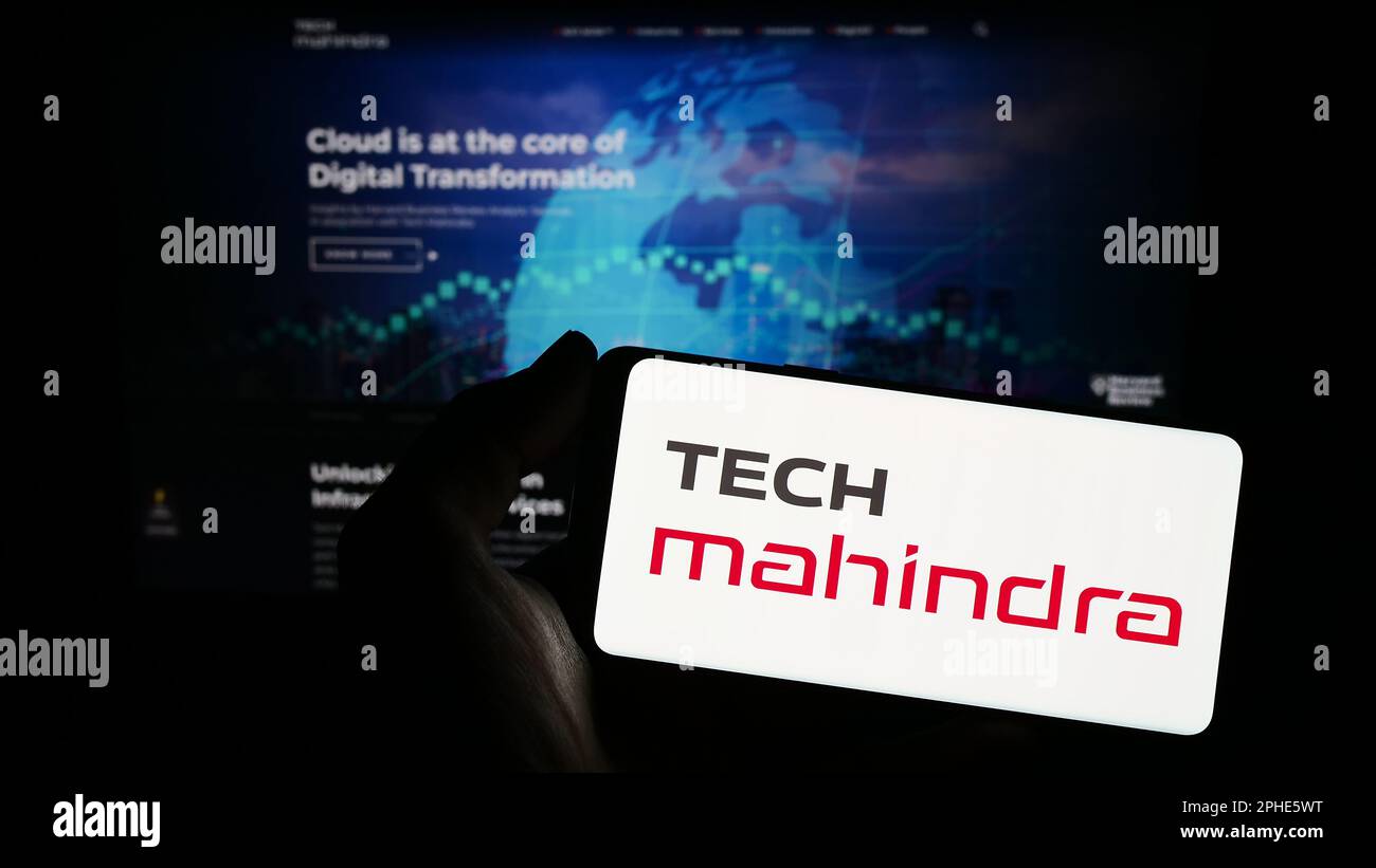 Person holding smartphone with logo of Indian IT company Tech Mahindra