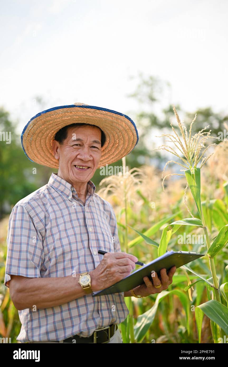 Portrait of an elderly Asian male farmer or farm owner in straw hat and