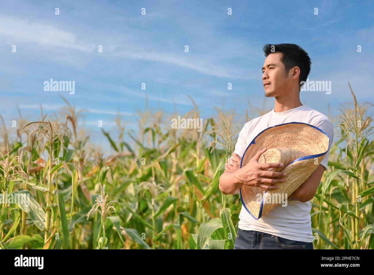 Successful millennial Asian male farmer or corn farm owner with his