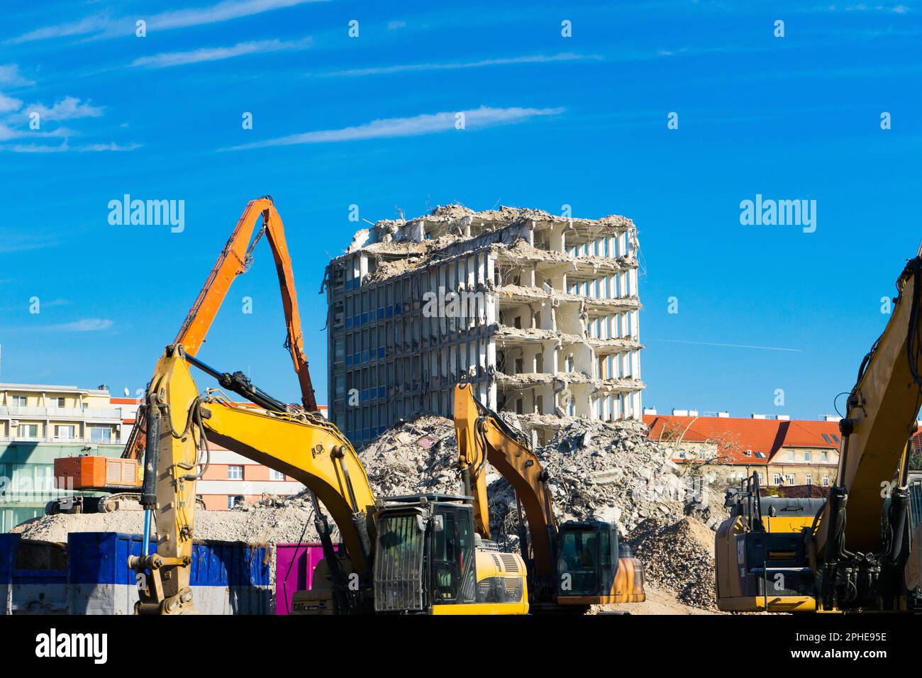 Demolition of the old building with sloopkraan against blue clouds sky ...