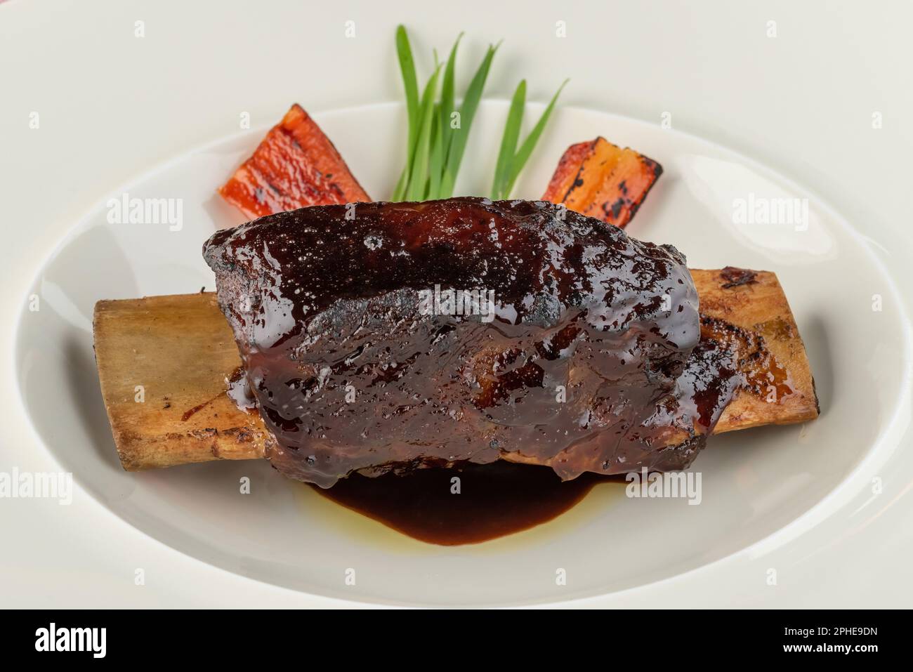 Long cooked marinated beef ribs on a white porcelain plate Stock Photo
