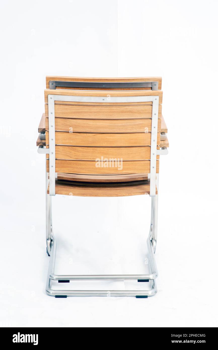 two wooden chairs with chrome metal frame stacked on top of each other isolated on a white