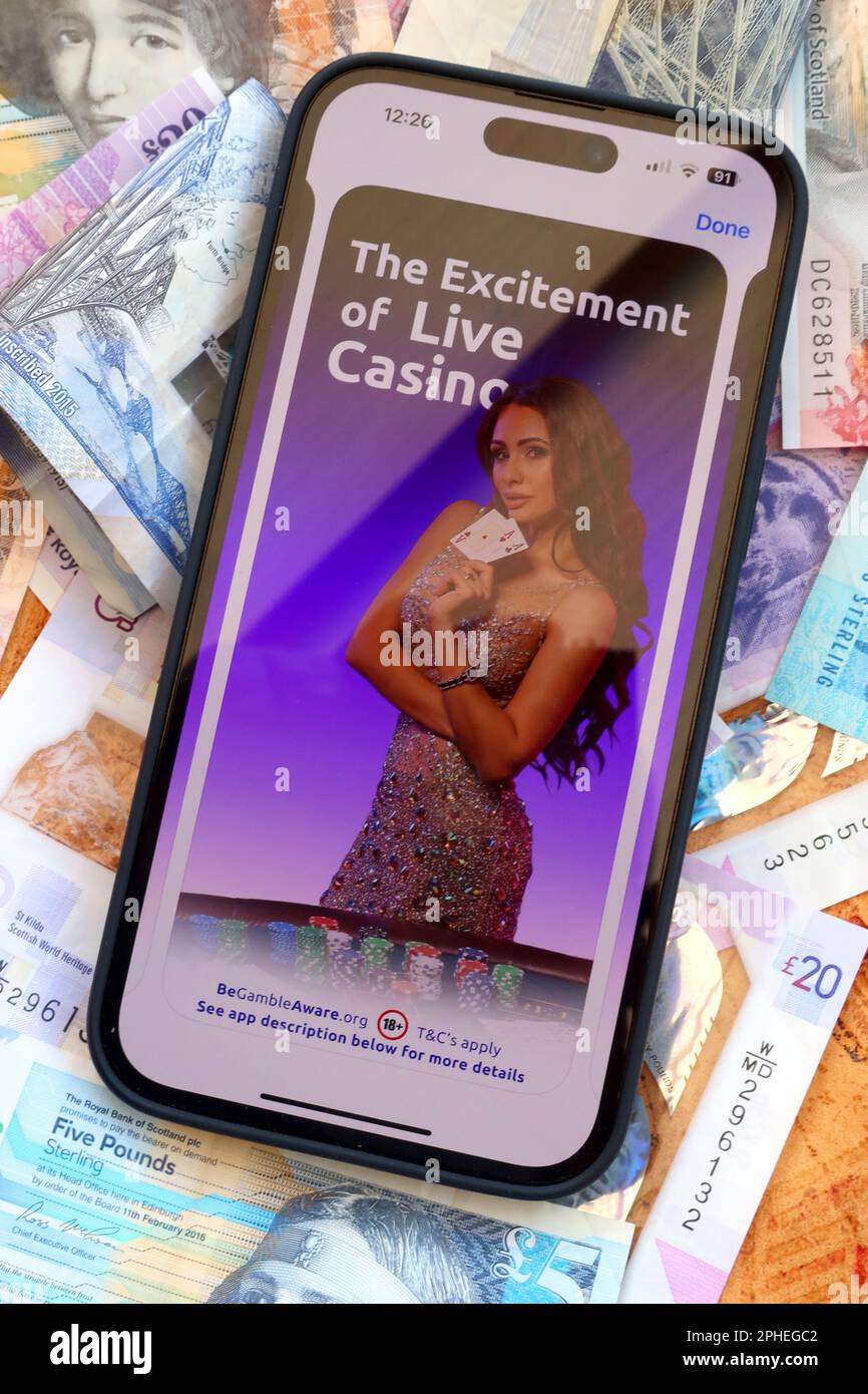 Live casino excitement - Online and smartphone casino, slots and gambling app with Scottish Sterling notes, money easily lost - BeGambleAware Stock Photo