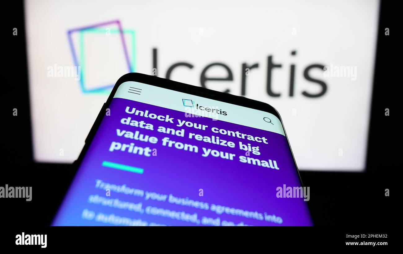 Mobile phone with website of US CLM software company Icertis Inc. on screen in front of business logo. Focus on top-left of phone display. Stock Photo