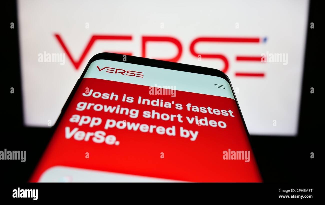 Smartphone with website of Indian company VerSe Innovation Pvt. Ltd. on screen in front of business logo. Focus on top-left of phone display. Stock Photo