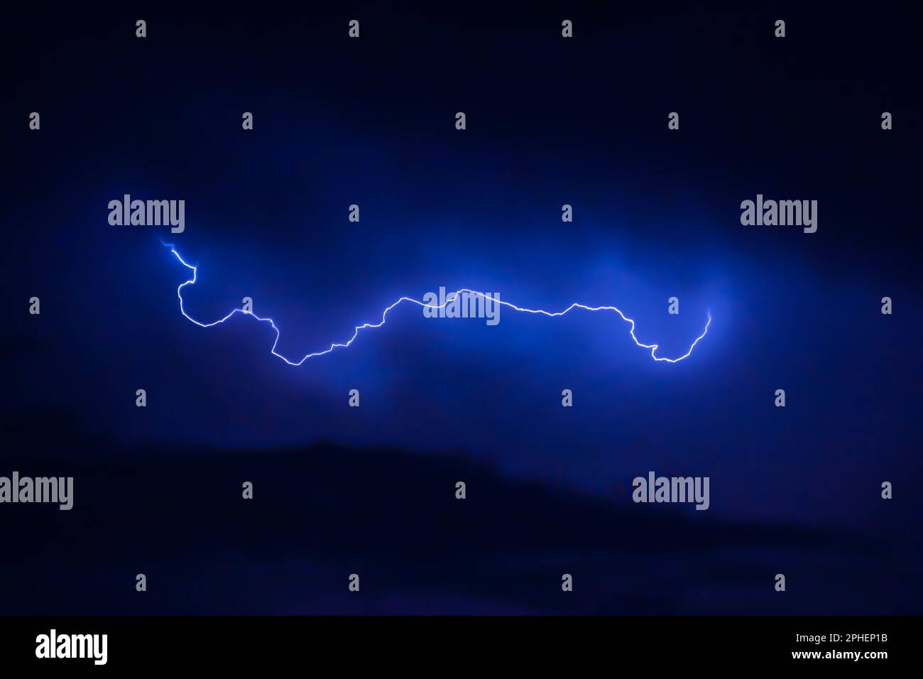 A dramatic shot of a dark night sky illuminated by a powerful lightning ...