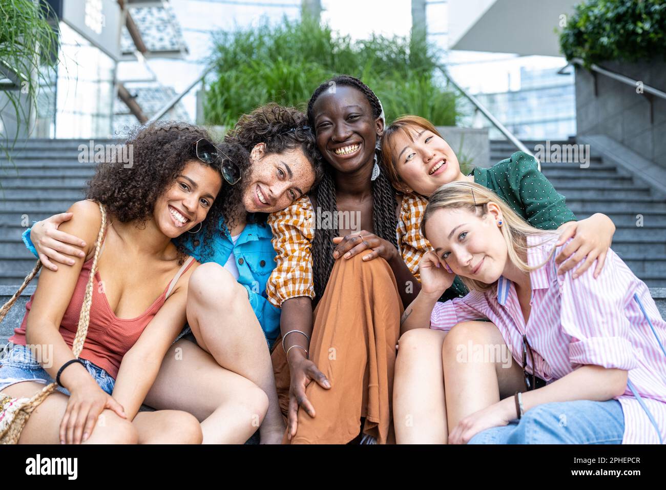 Front view portrait of a happy group of multiracial female friends looking at camera, enjoying outdoors, multiethnic cheerful young teenagers women Stock Photo