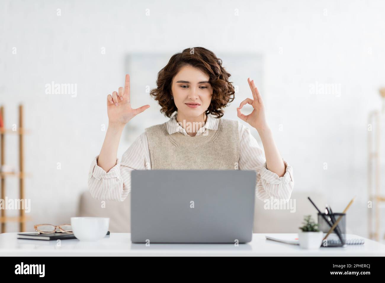 curly sign language teacher showing alphabet letters during online
