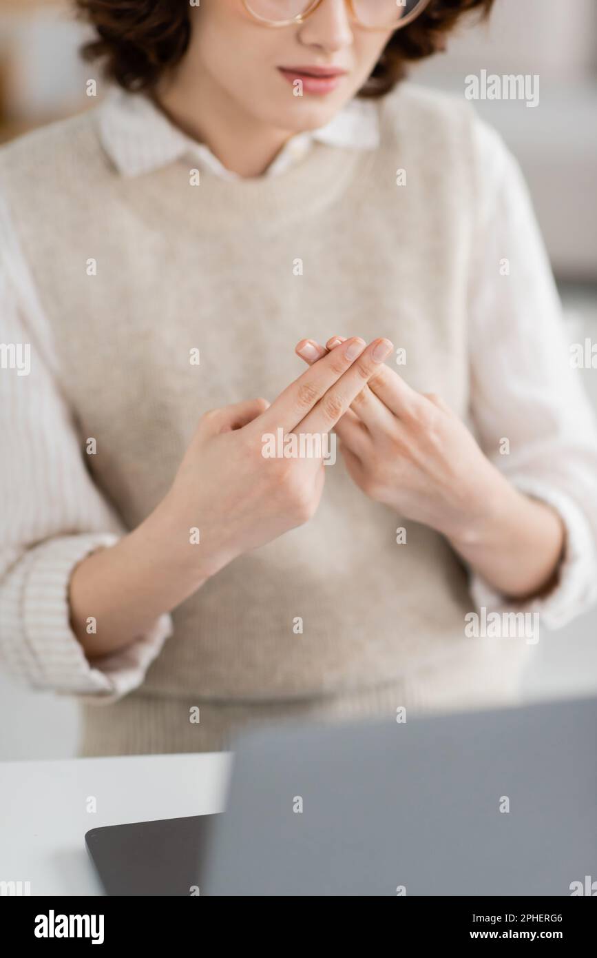 partial view of teacher showing british two handed sign alphabet meaning letter f during online lessonstock image 2PHERG6