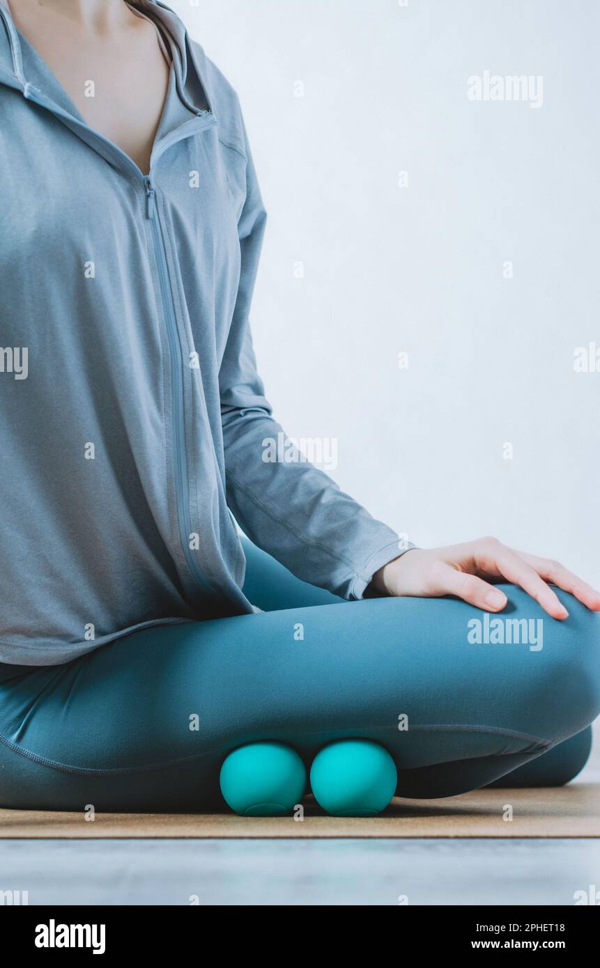 Person doing self myofascial release on outer leg with two therapy