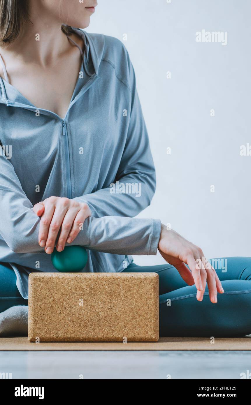 Woman doing forearm massage with therapy ball and cork block Stock