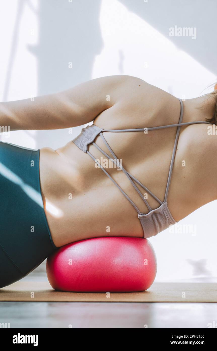 Woman doing side body breathing exercises with pilates ball Stock Photo