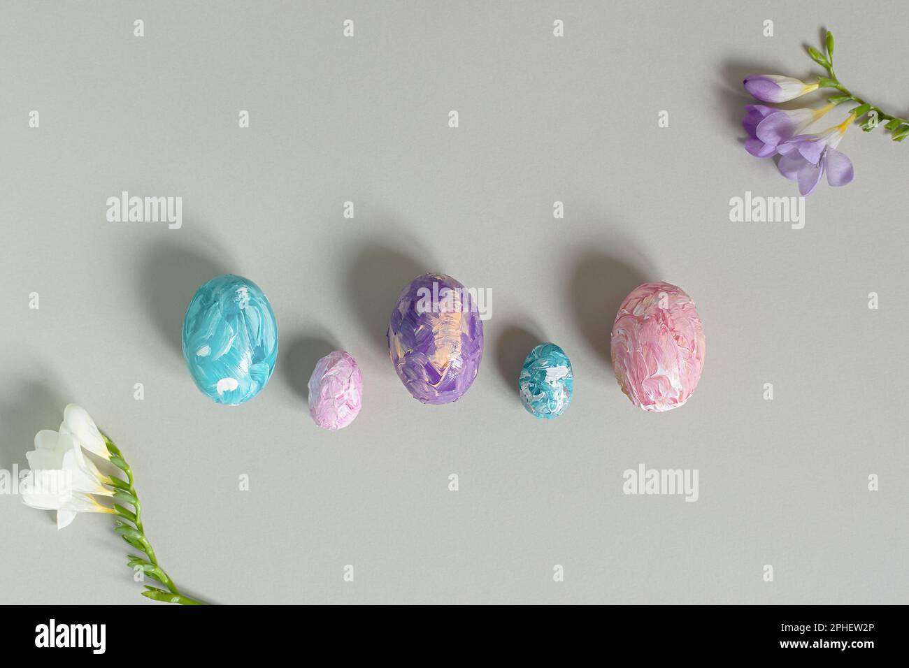 Happy Easter. Easter multicolored eggs on a light gray background. Greeting card, horizontal banner with copy space, top view. Creative Easter composi Stock Photo