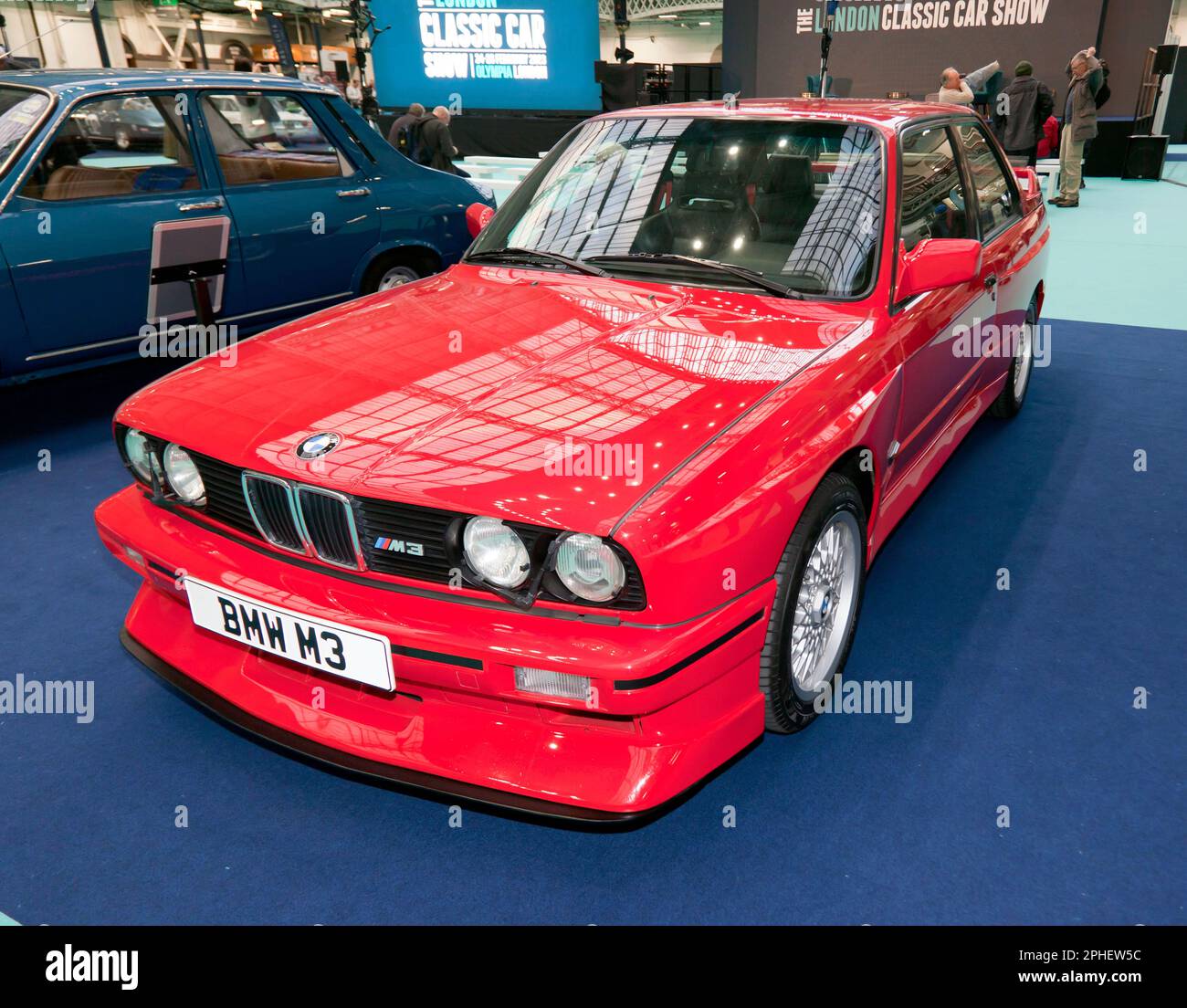 Three-quarters front view of a Red, E30 Generation, BMW M3, on display, at the 2023 London Classic Car Show Stock Photo