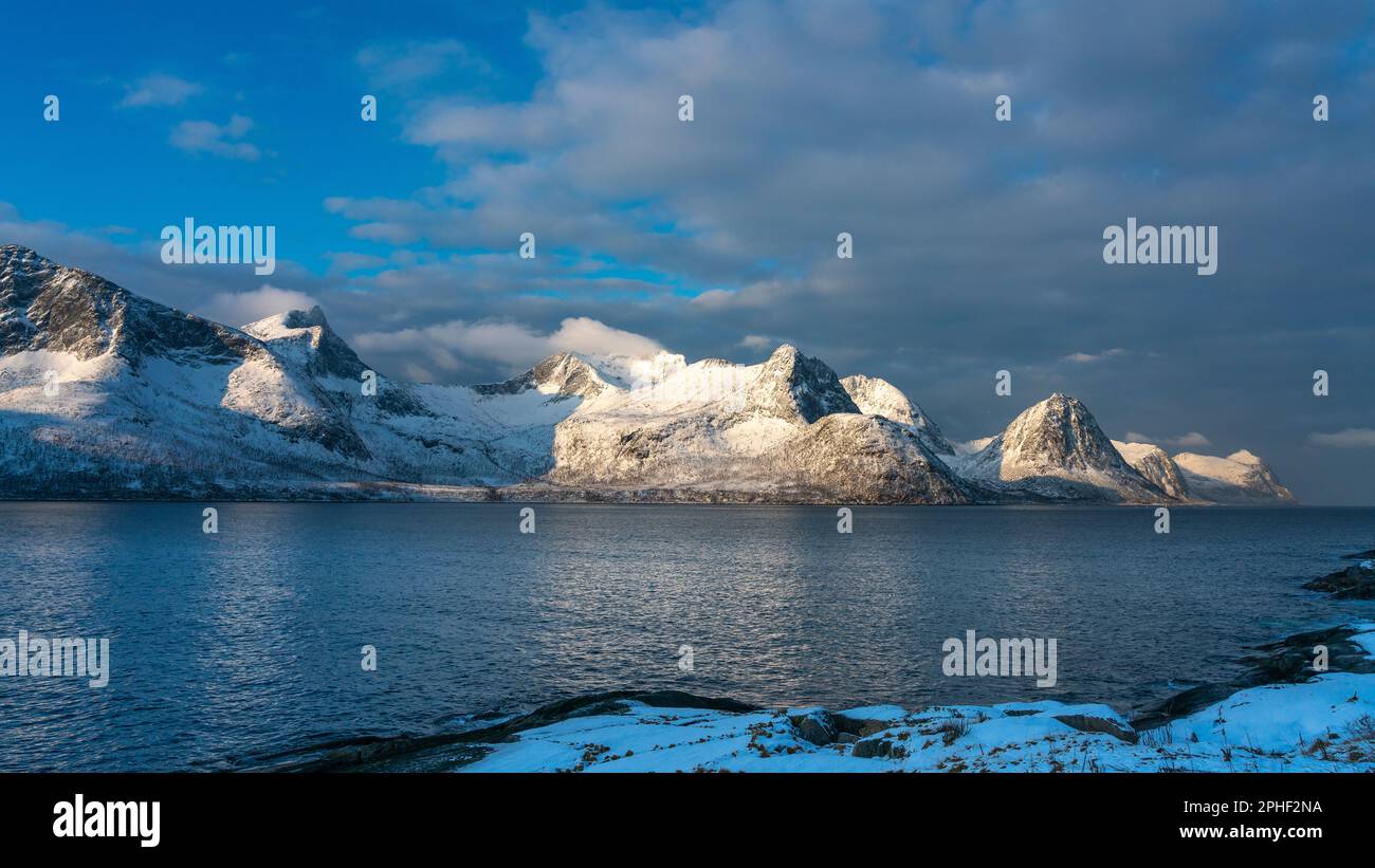 Øyfjorden im Morgenlicht, mit den schneebedeckten Bergen von Senja, genannt Segla, Kongan und Skultran im Hintergrund. Norwegen im Winter Stock Photo
