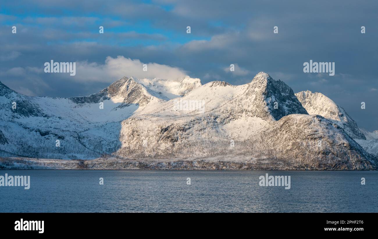 Øyfjorden im Morgenlicht, mit den schneebedeckten Bergen von Senja, genannt Segla, Kongan und Skultran im Hintergrund. Norwegen im Winter Stock Photo